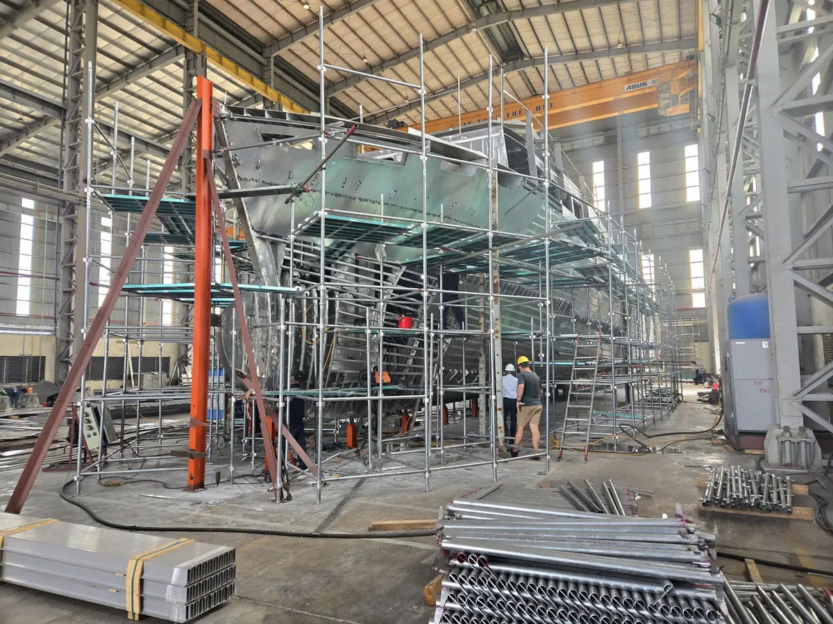 Aluminum yacht hull under construction in a shipyard